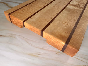 Detaljbild på handgjord skärbräda i björk och nyatoh med urfräst handtag, extra tjock och unik.