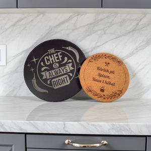 Runda grytunderlägg i skiffer och kork med graverade motiv