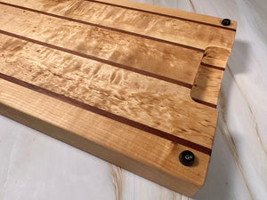 Handgjord unik skärbräda i björk och nyatoh, undersida med gummifötter för stabilitet.