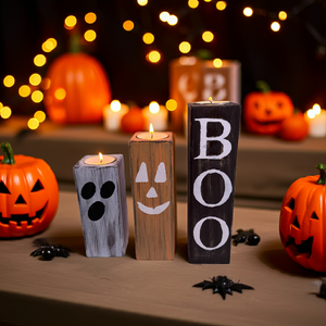 Handgjort Halloween-set i trä med tre rustika ljushållare målade som spöke, pumpa och texten BOO, dekorerat med ljus och pumpor.