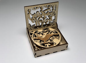 Närbild på julhängen i trä i utskuren presentask med texten Merry Christmas. Hantverk i trä från Norrgården.