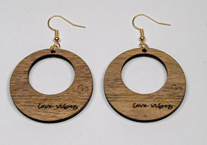 Örhängen i trä med texten Love Vibes graverat på sidan - perfekt att bära på alla hjärtans dag eller andra romantiska tillfällen