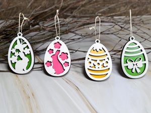 Set med fyra handgjorda påskhängen i trä och påskris