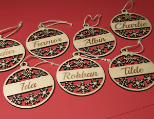 Personliga julhängen i trä med graverade namn som Farmor, Albin och Tilde, levererade i utskuren träask med texten Merry Christmas.