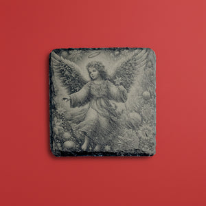 Vinterängel graverad på skifferunderlägg med mjuk illustration.