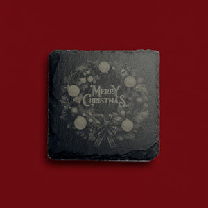 Julkrans med kulor och texten Merry Christmas graverad på skiffer.