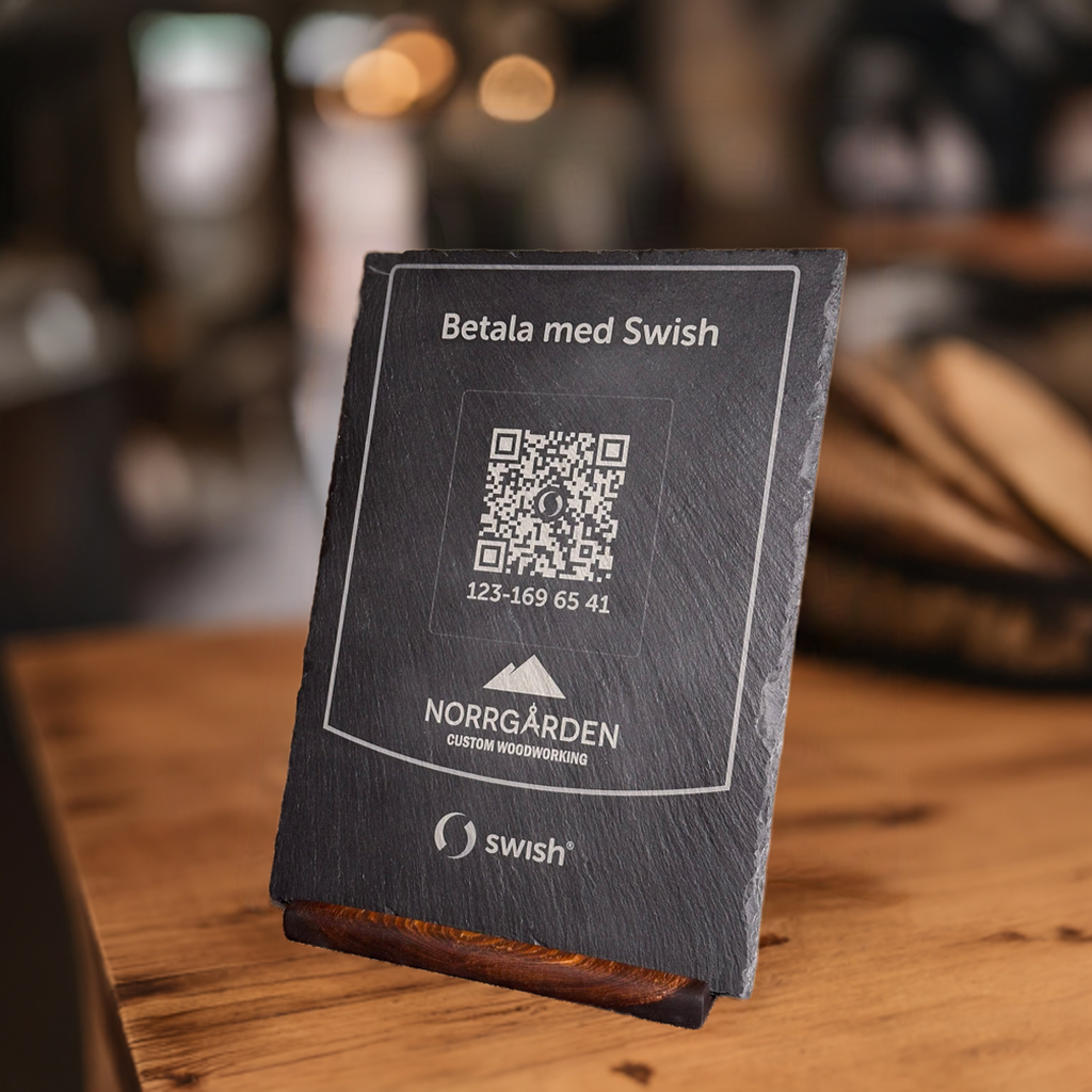 Graverad swishskylt i skiffer med QR-kod, logotyp och tillhörande träställ.