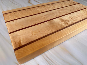 Handgjord exklusiv skärbräda i björk och nyatoh, fotograferad från sidan, extra tjock och tung.