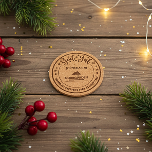 Korkunderlägg med julhälsning och graverad logotyp från Norrgården – exempel på företagsanpassad design för julen.