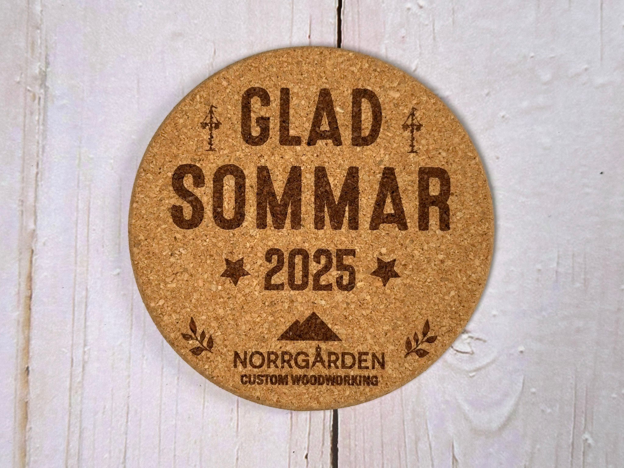 Personligt korkunderlägg för sommaren med graverad logotyp från Norrgården – exempel på företagsanpassad design.
