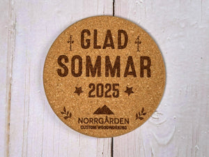 Personligt korkunderlägg för sommaren med graverad logotyp från Norrgården – exempel på företagsanpassad design.
