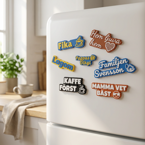 3D-printade kylskåpsmagneter med egen text – Fika, Lagom, Kaffe först, Familjen Svensson och Mamma vet bäst – på dörren till ett vitt kylskåp i ett ljust kök