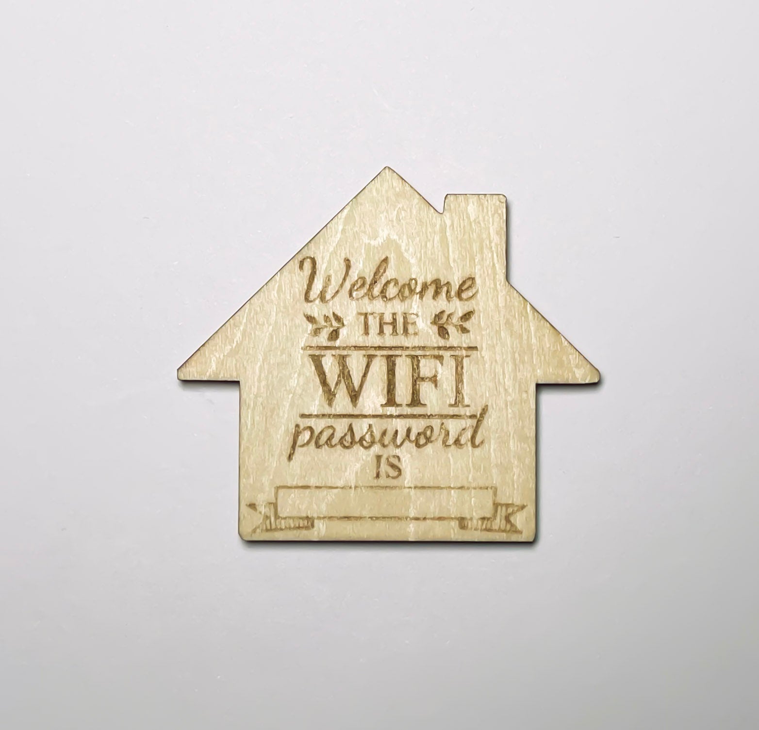 Kylskåpsmagnet i trä med texten Welcome the WiFi password is