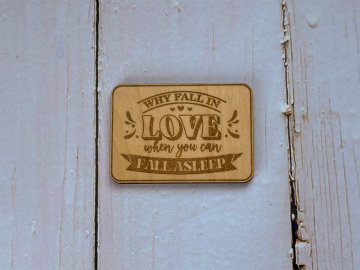 Magnet i trä med texten "Why fall in love when you can fall asleep" - perfekt som present till den som tröttnat på att jaga kärleken
