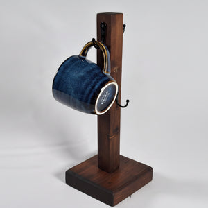 Detaljbild på handgjord mugghållare i trä med stor keramikkopp