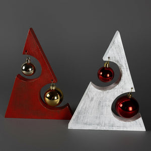 Två rustika handgjorda julgranar i trä, en röd och en vit, dekorerade med kulor – handgjorda av Norrgården i Fivelstad.