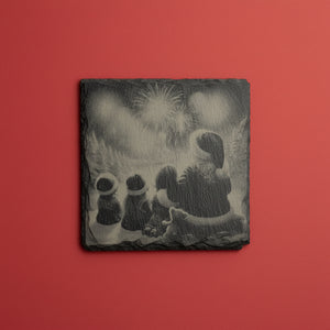 Tomtesiluett som tittar på fyrverkerier graverad på skifferunderlägg.