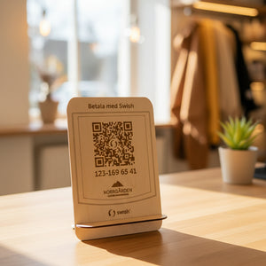 Swish-skylt i trä med graverad QR-kod för mobilbetalning.