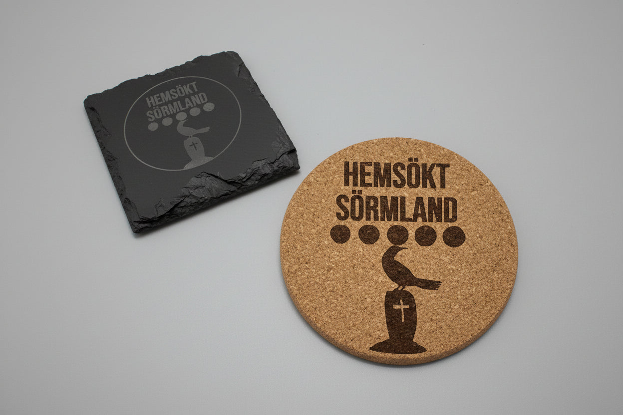 Underlägg i skiffer och kork graverade med logotyp för Hemsökt Sörmland.