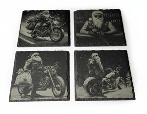 Underlägg i skiffer med graverade Biker-Santa-motiv, fotograferade mot neutral bakgrund. Visar detaljer i gravyren och den naturliga strukturen i stenen.