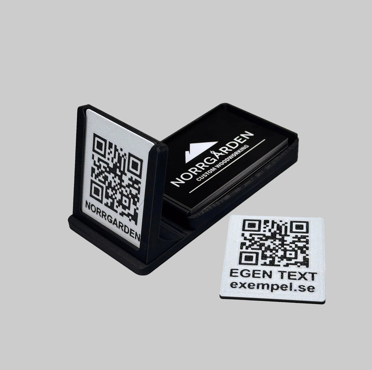 Svart visitkortshållare med QR-kod, fylld med visitkort och med en extra utbytbar skylt bredvid
