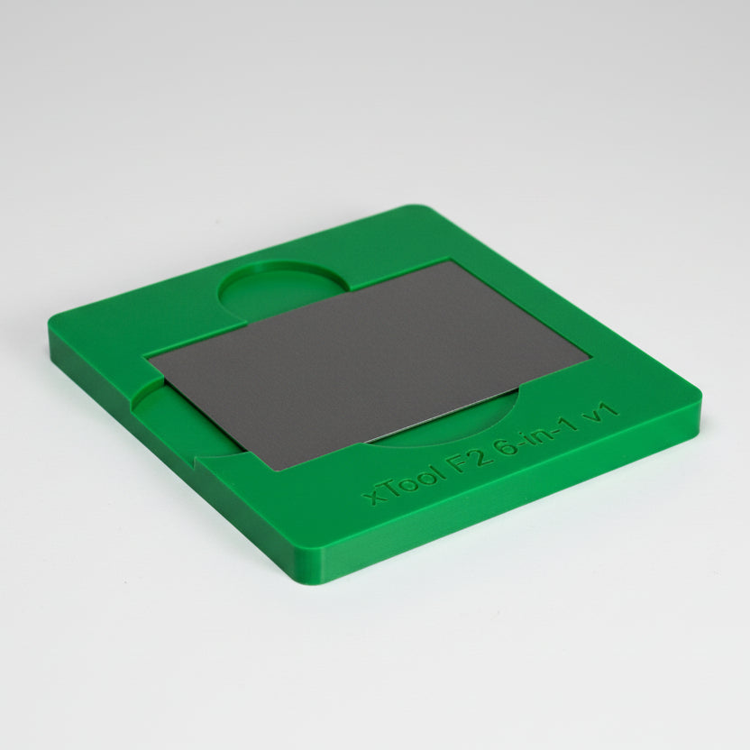 Visitkort placerat i batch-jigg för xTool F2 för exakt gravering